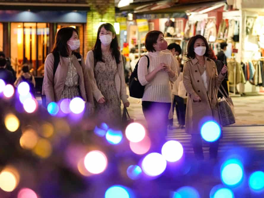 Pedestrians watch the seasonal illuminations in Tokyo as the crowds return to the capital.