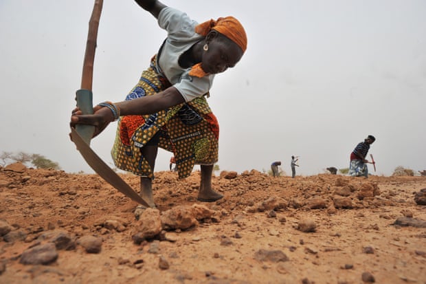 A Nigerien woman digs a trench to collect rainwater in the southern Zinder region.