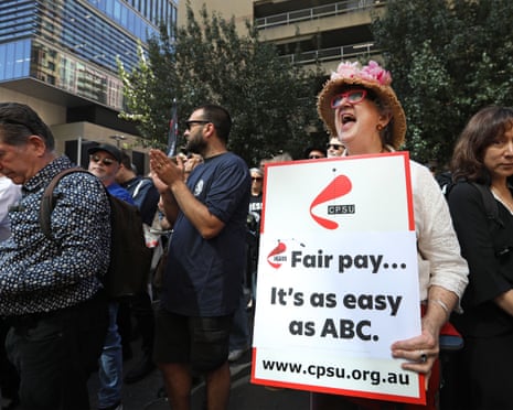 An ABC staff member holds up a union sign saying “fair pay … it’s as easy as ABC”.