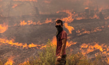 A man with a partially covered face near July wildfires in Rhodes, Greece