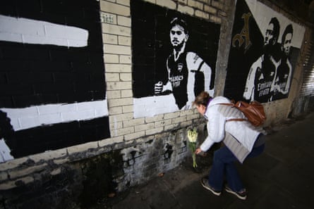 Flowers are placed below a mural of Billy Vigar in a tunnel outside the Emirates Stadium.