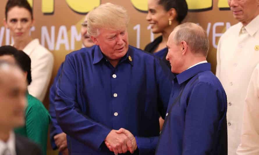 Donald Trump shakes hands with Vladimir Putin as they pose for a group photo ahead of the Apec summit gala dinner.