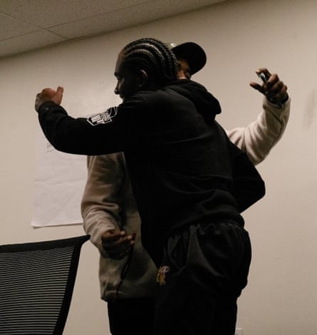 Two men embrace at the end of a men’s mental health session