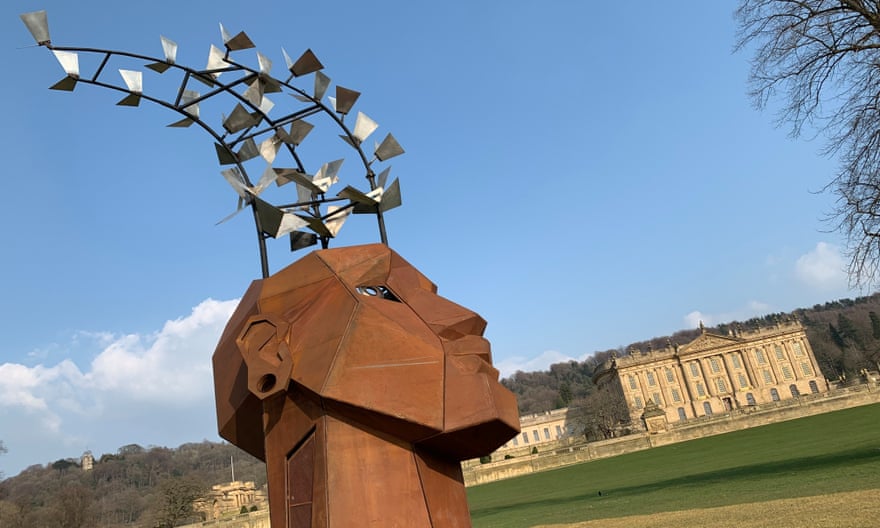 An angular metal head with metal plates attached to three curving poles coming out of the top – and Chatsworth House in the distance