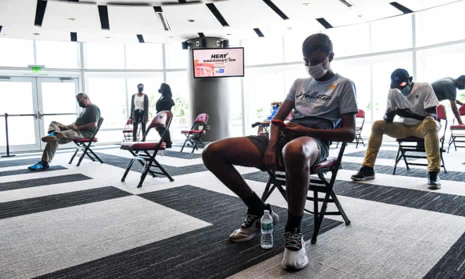 الناس ينتظرون في ساحة FTX في ميامي يوم الخميس بعد تلقي لقاح Govt-19.  تشير استطلاعات الرأي إلى أن مركزًا من الناس يقولون إنهم لن يحصلوا على اللقاح أبدًا.