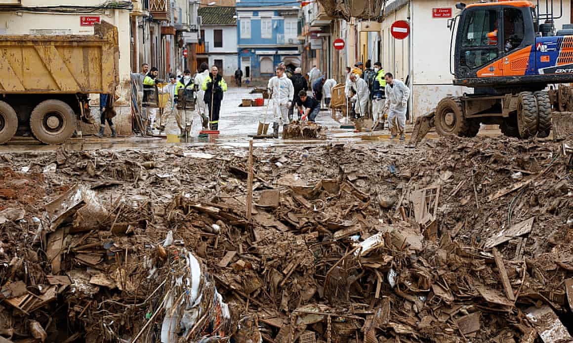Volunteers clean the street in Paiporta, where the death toll was 45.