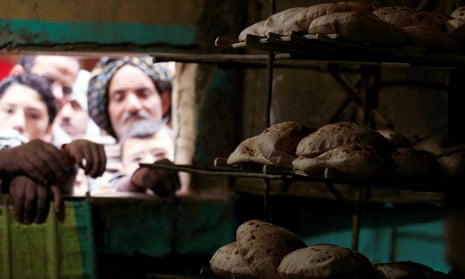 Men wait for bread at a hatch at a bakery