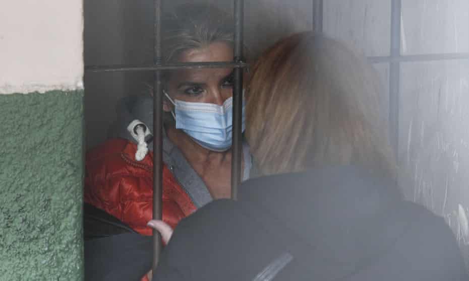 Standing behind bars, Bolivia’s former interim president Jeanine Anez speaks to an unidentified woman at a police station in La Paz.