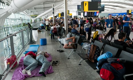 People sleep on a blanket at Heathrow airport’s terminal 5.