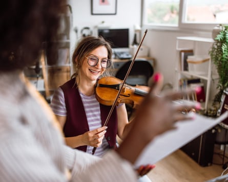 امرأة شابة تتعلم عزف الكمان.