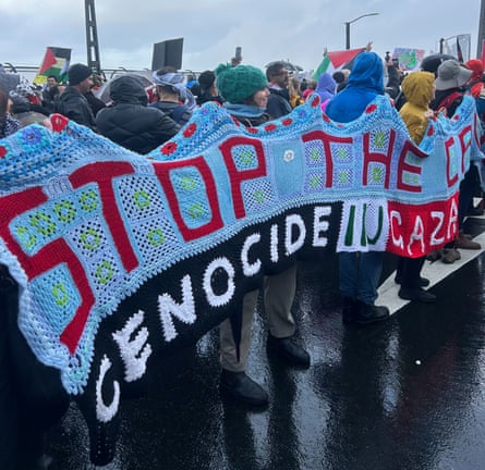 Marchers hold a crocheted banner