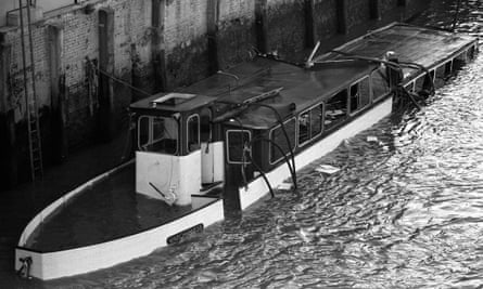 The wrecked hull of the Marchioness lying partially submerged in shallow water after it was hit by a dredger, Bowbelle, in August 1989.