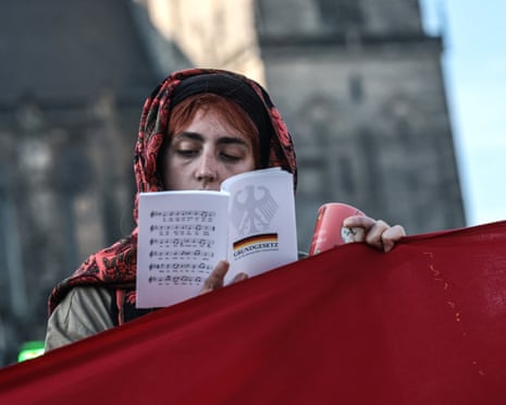 A woman reads a copy of the German constitution during a protest against the far-right Alternative for Germany (AfD) party.