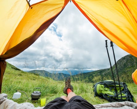 The legs of a traveller in hiking boots in a tent outdoors on Carpathian mountain.