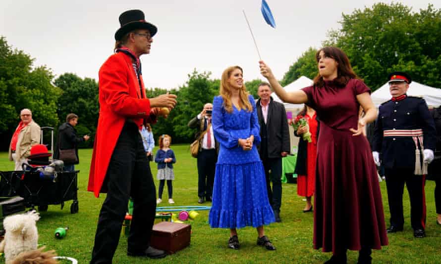 La princesa Eugenie intenta hacer girar el tablero y la princesa Beatrice (izquierda) la observa en el Gran Almuerzo del Jubileo en el Paddington's Entertainment Arena.