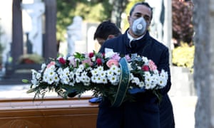 Funeral workers transport the coffin of a coronavirus victim into a cemetery in Bergamo