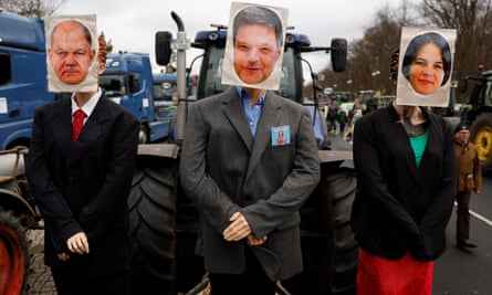 A tractor decorated with dummies with images of (from left) the German chancellor Olaf Scholz, the economy minister Robert Habeck, and foreign minister Annalena Baerbock