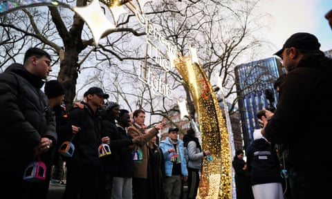 Robert Rigby with children holding lanterns under an illuminated sign that says ‘Spread the Light’