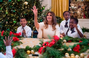 Melania throws a Christmas ornament as she makes garlands with children in the east wing