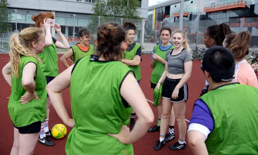 Women stand talking on the pitch