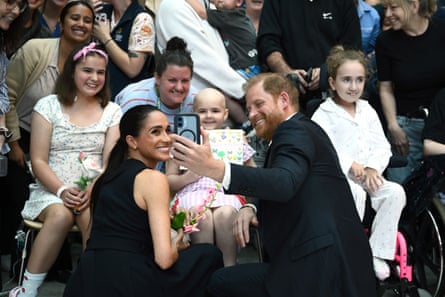 The couple pose for a selfie with a young patient and her family