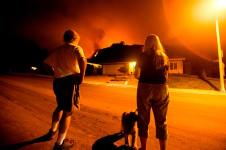 People watch as the Bobcat Fire burns on hillsides behind homes in Monrovia, California on September 15, 2020.
