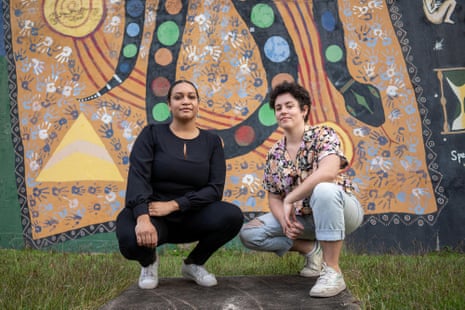 Youth Verdict’s co-directors, Murrawah Johnson and Monique Jeffs crouching in front of Indigenous artwork.