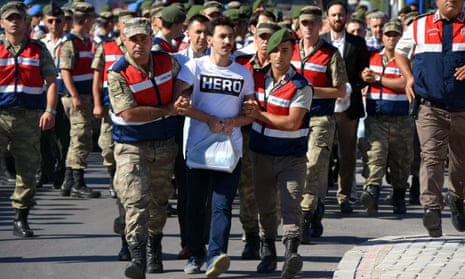 Turkish gendarmes escort a former army special forces officer wearing a ‘Hero’ T-shirt.