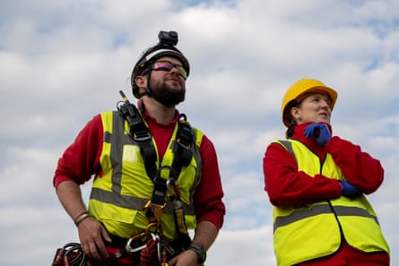 Sheldon and Middleton, in hi-vis vests and helmets, looking up at something