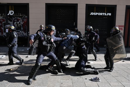 French riot police detain a protester on the ground during a Marseille demonstration