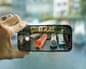 A hand holding an Apple iPhone 17 focusing on narrow boats for a picture