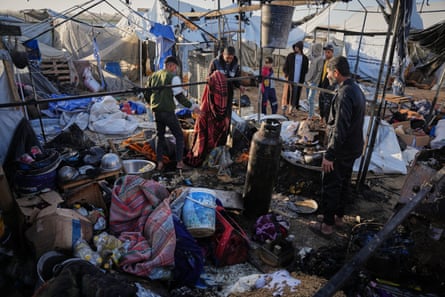 Palestinians inspect damage to a tent hit by an Israeli strike in Khan Younis. Belongs are strewn on the ground and only tent poles remain