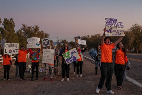 people hold up signs along a road
