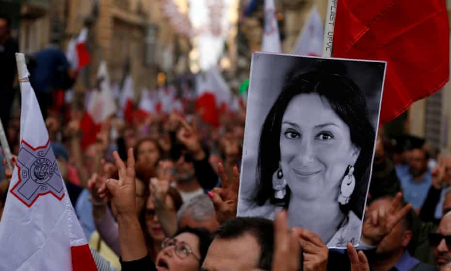 A demonstrator carries a picture of the murdered Maltese journalist Daphne Caruana Galizia in a protest in Valletta, Malta, in April