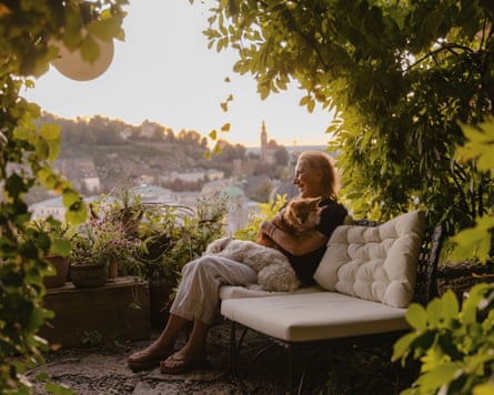 Doris Rüggeberg in her garden next to the villa with a cat