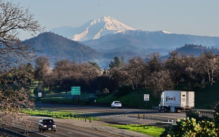 Mountains behind a highway where are cars driving by