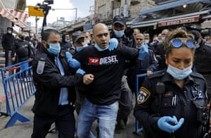 A stallholder is arrested at the Mahane Yehuda market during scuffles between security forces and protesters, angry about the continued closure of the landmark open air market, whilst many shops have been allowed to re-open