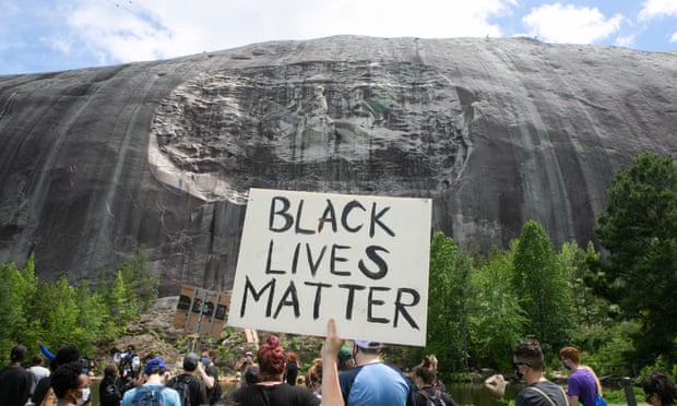Black Lives Matter Holds Protest Over Recent Police Killings In Stone Mountain, Georgia<br>STONE MOUNTAIN, GA - JUNE 16: A protestor holds a Black Lives Matter sign in front of the Confederate carving in Stone Mountain Park on June 16, 2020 in Stone Mountain, Georgia. The march is to protest confederate monuments and recent police shootings. Stone Mountain Park features a Confederate Memorial carving depicting Stonewall Jackson and Robert E. Lee, President Jefferson Davis. (Photo by Jessica McGowan/Getty Images)