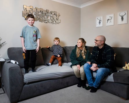 Fraser stands astatine connected nan sofa, looking astatine nan camera. Archer stands adjacent Fraseron nan sofa leaning against nan backmost of it, and Alison and Andy are sitting astatine nan different extremity of nan sofa, looking astatine Fraser and smiling