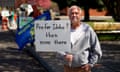 A man wearing a gray sweatshirt holds up a sign reading "Prefer Idaho? then move there"