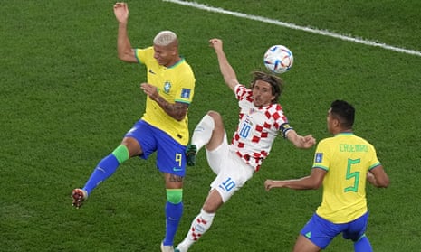 Croatia's Luka Modric, center, duels for the ball with Brazil's Richarlison, left, and Brazil's Casemiro.
