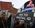 Demonstrators hold up placards saying 'No to digital ID' and 'I would rater be a human not a slave' during a march against the implementation of digital ID cards, in central London on 18 October 2025
