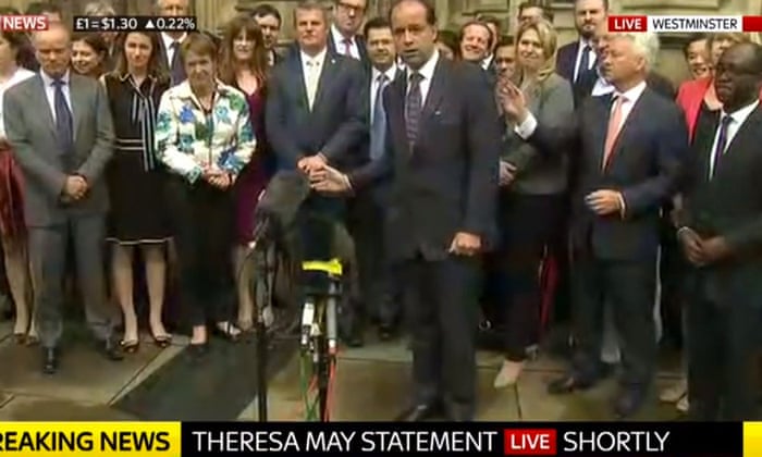 MPs waiting for Theresa May to speak outside parliament.