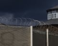 Coiled razor wire tops a security fence at HMP Wandsworth in London.