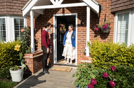 Alistair Strathern talks to a woman standing at the door of a house