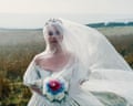 Actor Margot Robbie standing on the Yorkshire moors in a bridal dress, and holding a small bouquet of flowers, while filming her new movie Wuthering Heights.