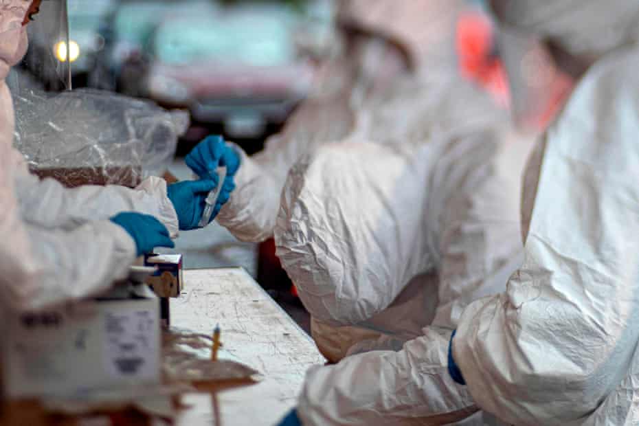 Medical technicians processing specimens at a Covid-19 testing site in Holmdel, New Jersey, on 23 March.