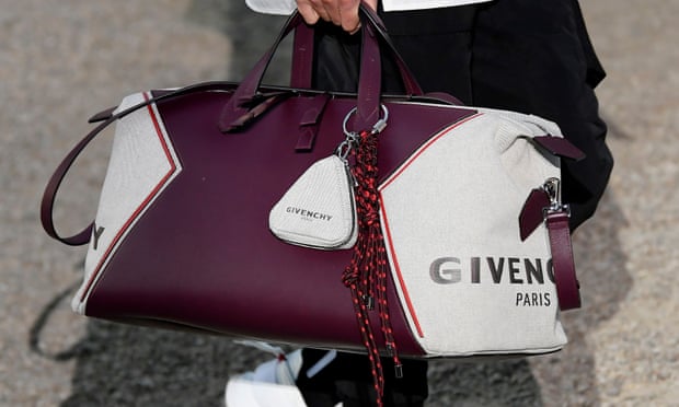 A branded Givenchy bag is carried by a model