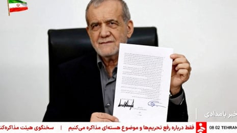 Masoud Pezeshkian holding up a document with his signature and Donald Trump's.
