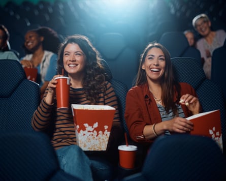 Young happy women watching movie in cinema.